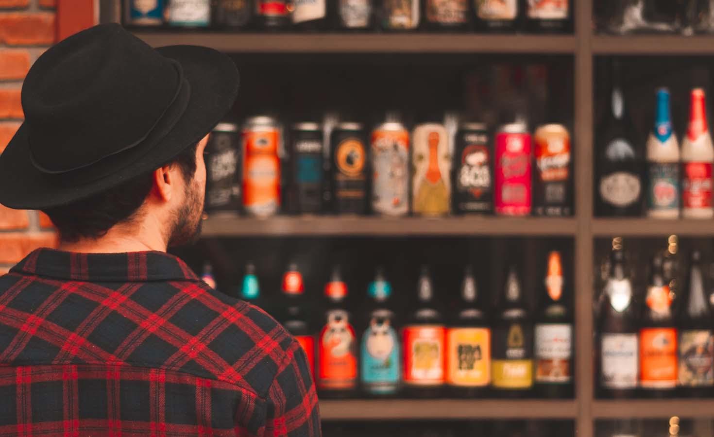 Man looking at shelf full of beer bottlers