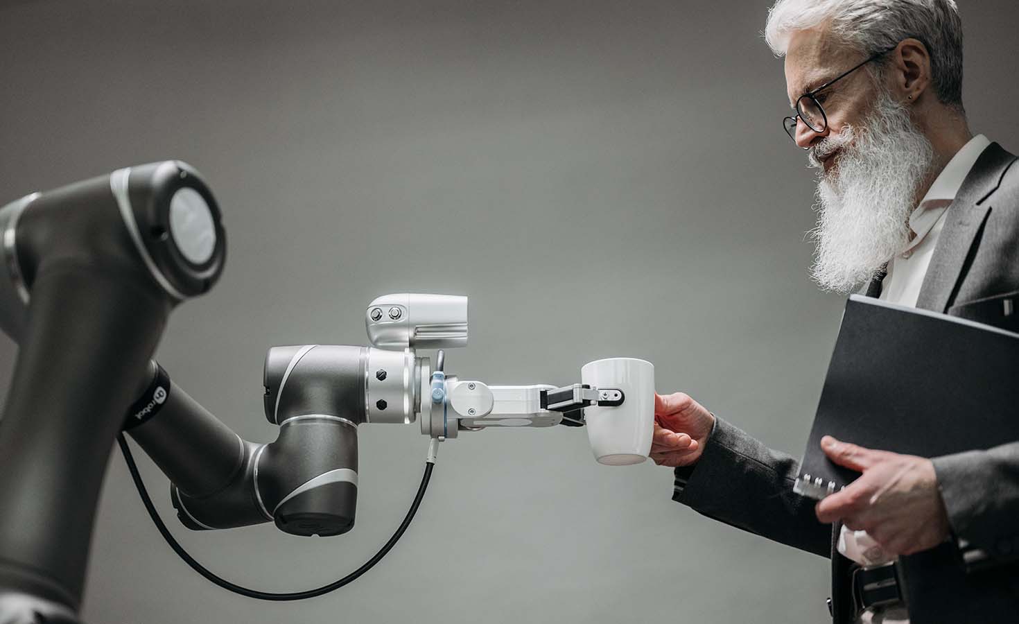 Robotic arm hading a man a cup